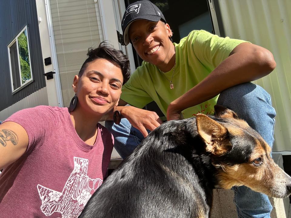 the couple and their dog in front of tiny home