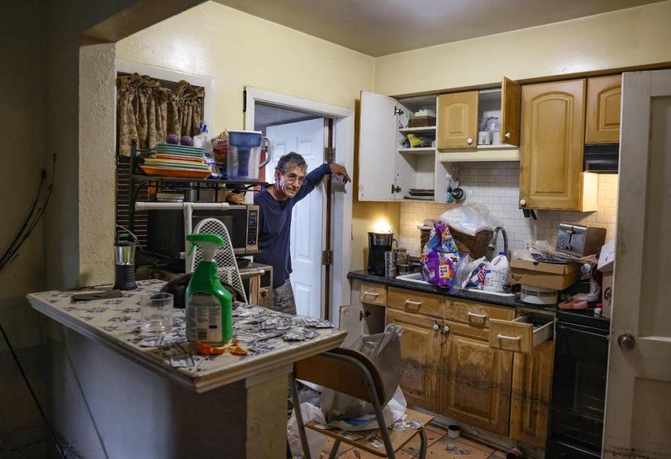 Paul Guerrero pauses to assess the damage while a restoration company surveys his home. Carl Juste/cjuste@miamiherald.com