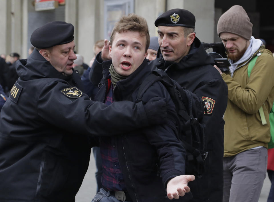 FILE - Belarus police arrest journalist Raman Pratasevich, center, in Minsk, Belarus, Sunday, March 26, 2017. Federal prosecutors in New York have charged four Belarusian government officials with aircraft piracy for diverting Ryanair flight 4978 last year to arrest Pratasevich. (AP Photo/Sergei Grits, File)