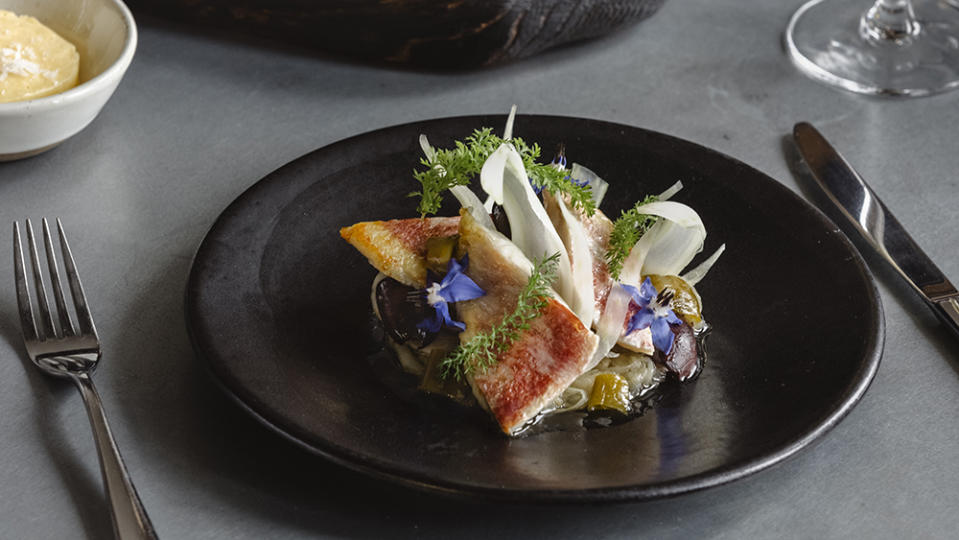 A starter of charred sea trout is served with focaccia baked with grapes from the vineyard at its Michelin-recommended restaurant, Tasting Room. 