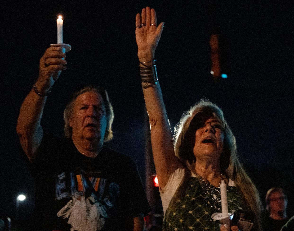 Cara Marie holds her hand in the air as she sings along to “If I Can Dream” on Elvis Presley Boulevard in front of the gates of Graceland during the annual Candlelight Vigil to honor Elvis Presley in Memphis, Tenn., on Thursday, August 15, 2024. Marie, from Branson, Missouri, said she saw Presley perform “How Great Thou Art” when she was 13. “I have an everlasting gratefulness to him,” she said. “It changed my life.”