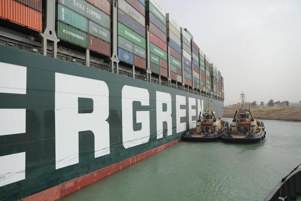 An image released on March 25, 2021 by Egypt's Suez Canal Authority shows tug boats alongside the hull of the MV Ever Given container ship, which was stuck across the canal for a third day.  / Credit: Suez Canal Authority