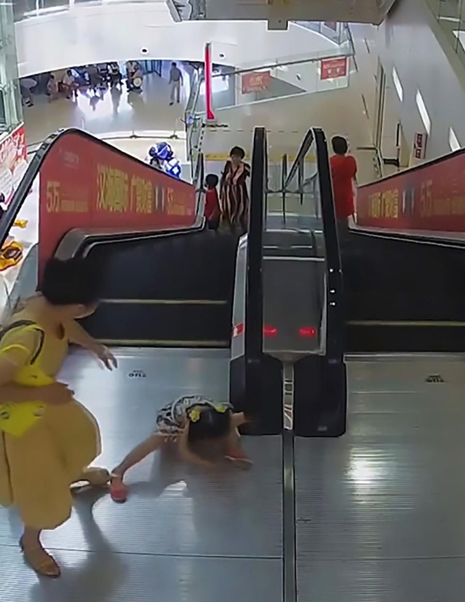 A young girl's arm becomes stuck in a handrail of an escalator. Source: AsiaWire/Australscope