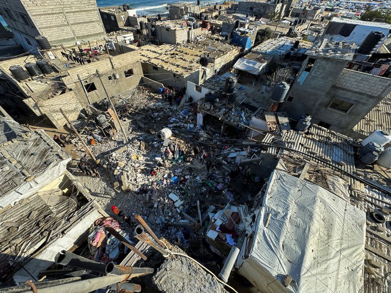 Palestinos inspeccionan el lugar de un ataque israelí contra una casa, en medio del actual conflicto entre Israel y el grupo islamista palestino Hamás, en Rafah, en el sur de la Franja de Gaza