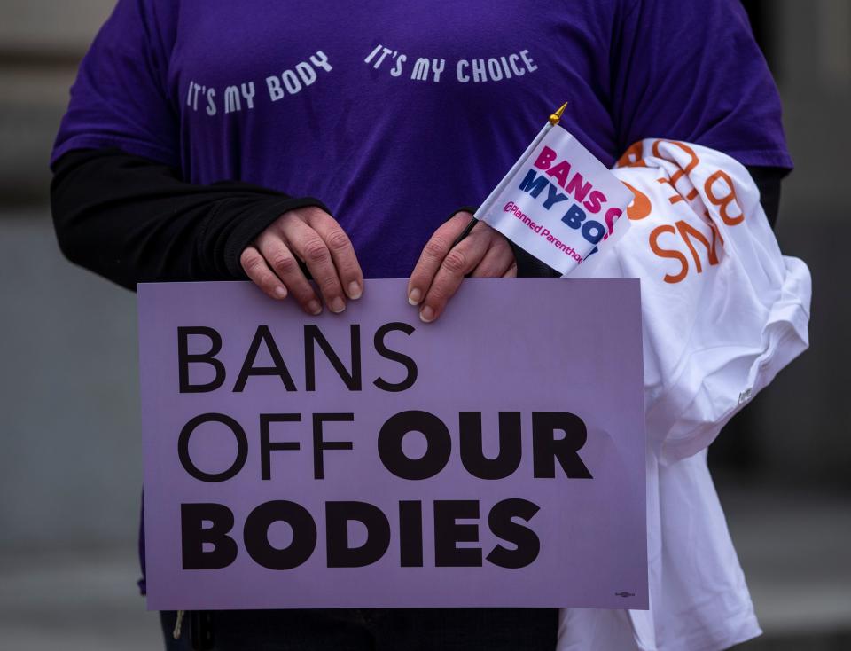 A protester holds a sign in front of the Kentucky State Capitol in Frankfort over House Bill 3, which would restrict abortions in the state. March 29, 2022