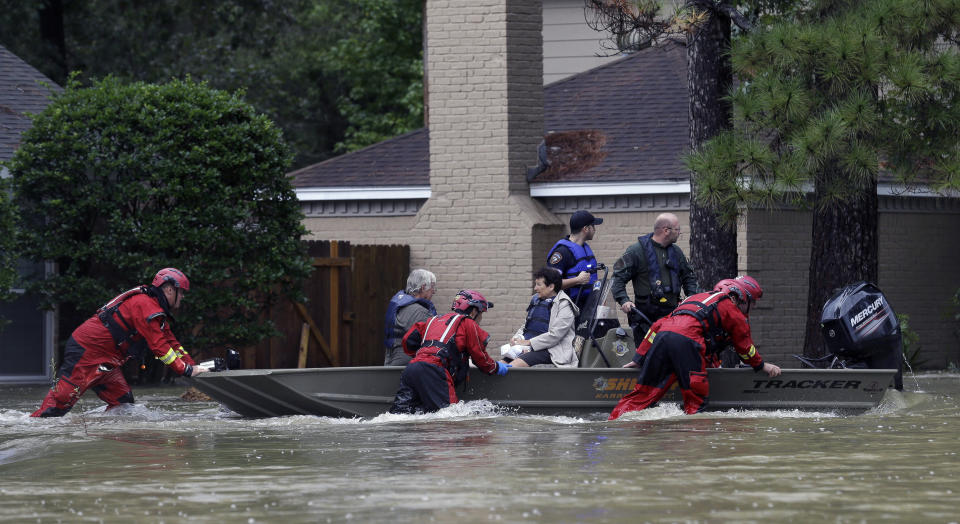 Members of the Texas Game Warden rapid water rescue team push a Harris County Sheriff's Office boat out of shallow water while evacuating Larry and Carrie LeBlanc Friday, Sept. 20, 2019, in Huffman, Texas. Emergency workers used boats Friday to rescue about 60 residents of a Houston-area community still trapped in their homes by floodwaters following one of the wettest tropical cyclones in U.S. history. (Godofredo A. Vásquez/Houston Chronicle via AP)