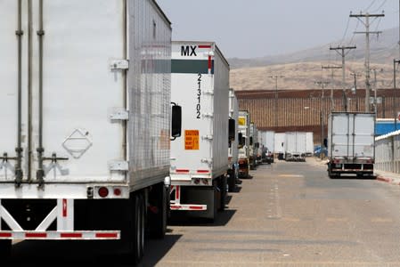 Trucks wait in queue for border customs control at the Otay border crossing in Tijuana