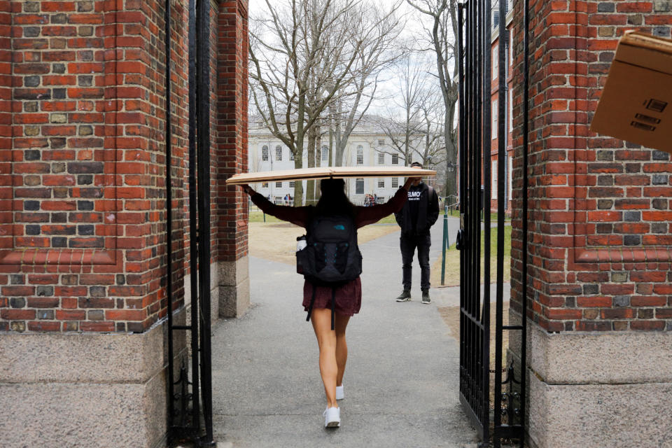 A student carries a box to her dorm at Harvard University.