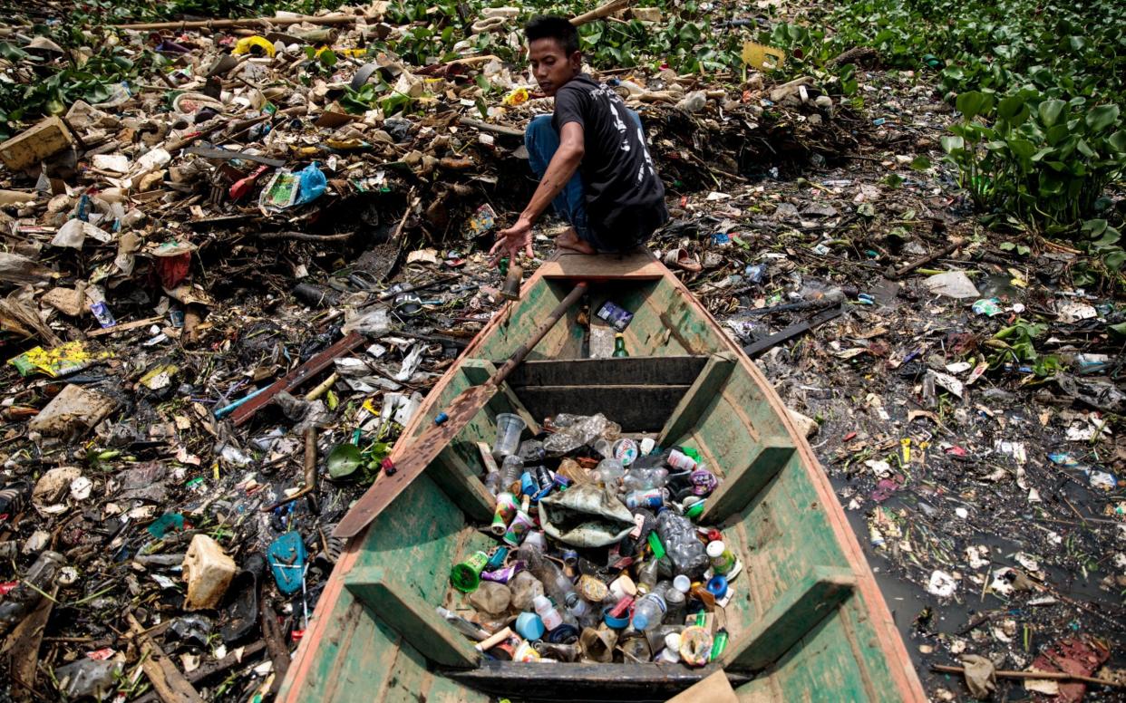 Rudiana, 24 from Cihampelos Village, collecting plastic in 2019 at the Saguling reservoir on the headwater of the Citarum river in Bandung, Java, Indonesia. The Citarum is considered one of the most polluted in the world and the Indonesian Army has been tasked with cleaning it up as part of an ambitious 7 year project - Jack Taylor