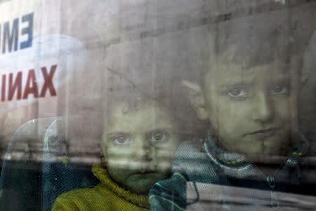 Syrian children are seen inside a bus following their arrival by the Eleftherios Venizelos passenger ferry with over 2,500 migrants and refugees from the island of Lesbos at the port of Piraeus, near Athens, Greece, October 8, 2015. REUTERS/Yannis Behrakis