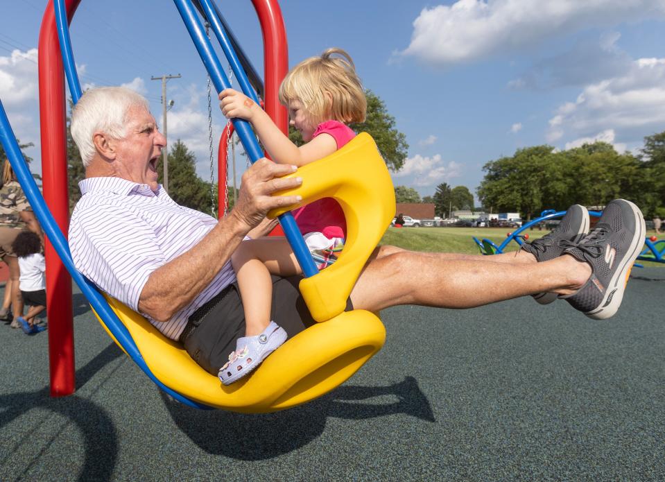 Dennis Brennan and his granddaughter Florence Babel, 3, play on the new Southeast Community Playground in Canton at the Habitat for Humanity dedication celebration.