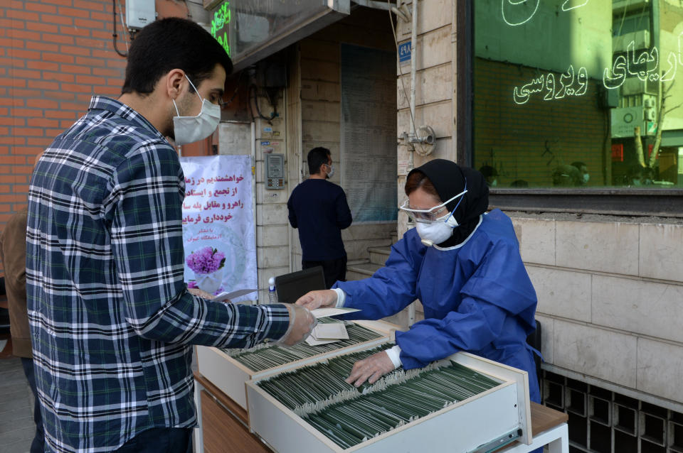 Patients wait for their results in front of the Keyvan Virology Laboratory to confirm the coronavirus cases in Tehran.