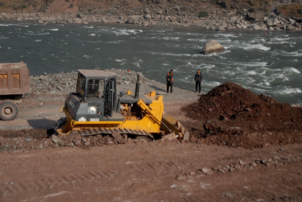 File A Chinese engineer (R) supervise workers preparing a road along a river in Ghari Dopatta, some 22 kms from Muzaffarabad, the capital of Pakistani-administered Kashmir in 2013  (AFP via Getty Images)