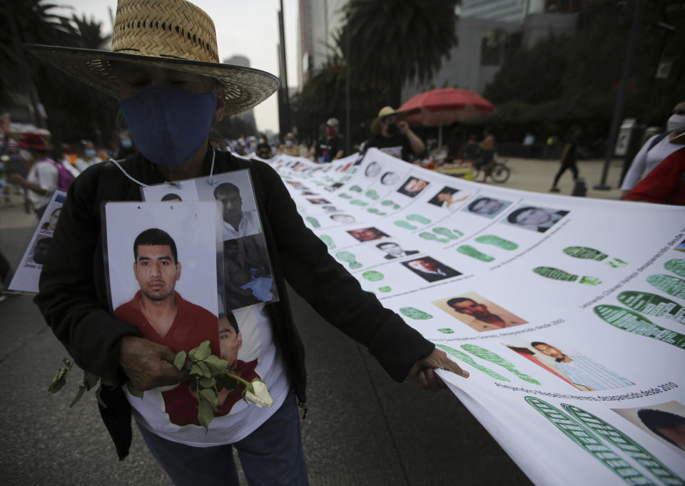 A person holds a portrait during a march in remembrance of those who have disappeared, on Mother's Day in Mexico City, Monday, May 10, 2021. (AP Photo/Fernando Llano)