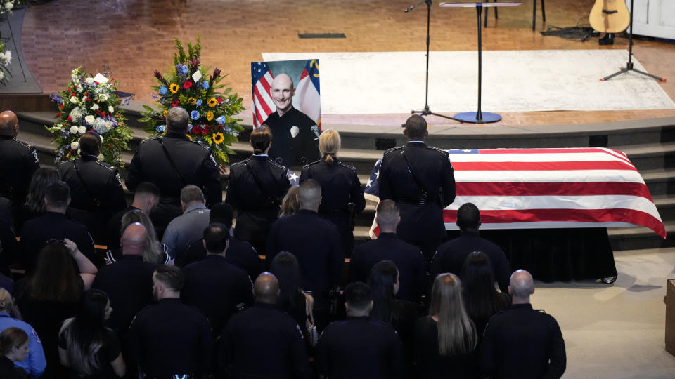 Officers stand during a memorial service for Officer Joshua Eyer, Friday, May 3, 2024, in Charlotte, N.C. Police in North Carolina say a shootout that killed Eyer and wounded and killed other officers began as officers approached a home to serve a felony warrant on Monday. (AP Photo/Chris Carlson)