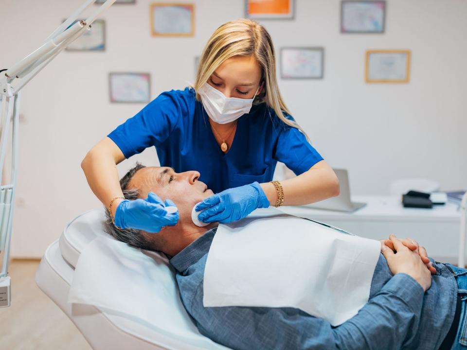 Female dermatologist using cotton pads on a patient’s face