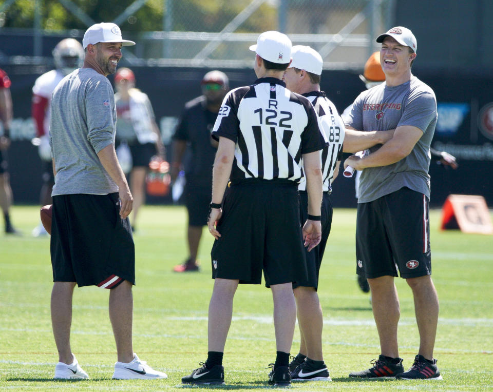 San Francisco 49ers head coach Kyle Shanahan, left, and general manager John Lynch, right, laugh with the referees during practice at the team's NFL football training facility in Santa Clara, Calif., Tuesday, June 11, 2019. (AP Photo/Tony Avelar)