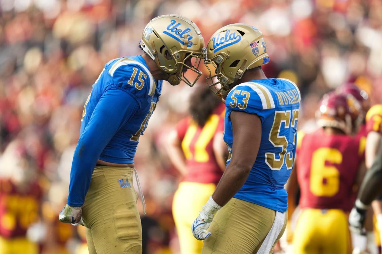 UCLA defensive lineman Laiatu Latu and linebacker Darius Muasau celebrate after the Bruins recorded a sack