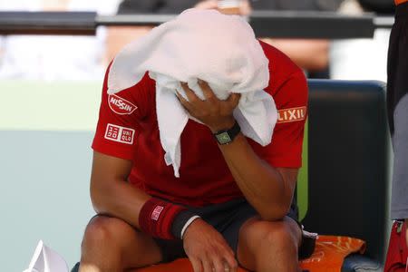 Mar 29, 2017; Miami, FL, USA; Kei Nishikori of Japan holds a towel over his head during a changeover against Fabio Fognini of Italy (not pictured) on day nine of the 2017 Miami Open at Crandon Park Tennis Center. Fognini won 6-4, 6-2. Geoff Burke-USA TODAY Sports