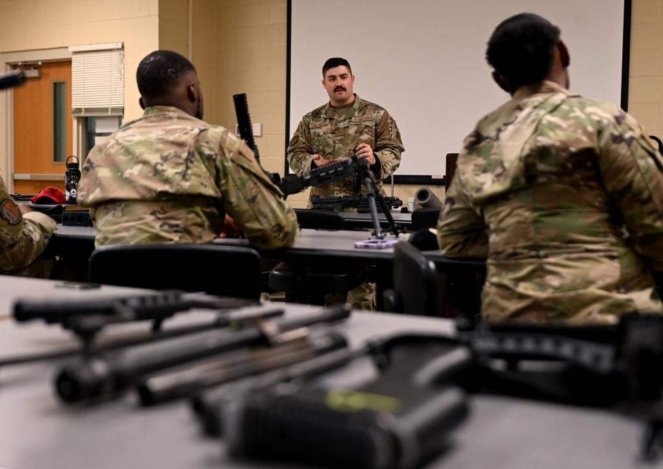 Staff Sergeant Emilio San Miguel (center), 908th Security Forces Squadron combat arms training and maintenance instructor, gives a briefing to some of the members of the 908 SFS July 9, 2022, at Maxwell Air Force Base, Alabama. The briefing was about the specifications, situational uses, handling, disassembly, and reassembly of the M240B machine gun and the M249 light machine gun.