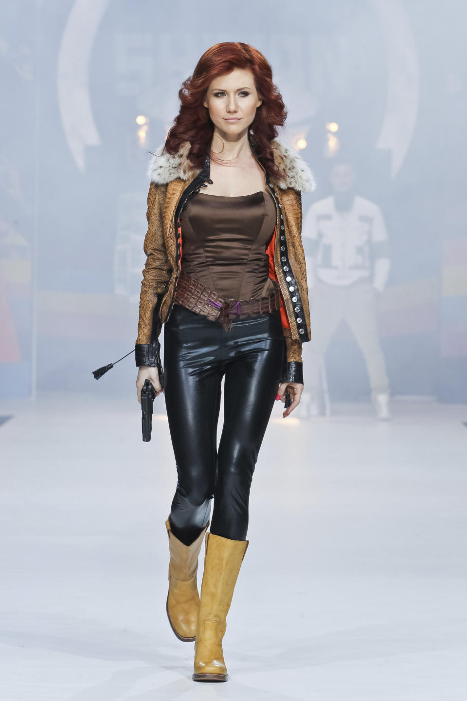 FILE. In this file photo taken on Sunday, April 3, 2011, Anna Chapman, who was deported from the U.S. on charges of espionage, displays a creation by Russian designers Shiyan & Rudkovskaya during a Fashion Week in Moscow, Russia. Chapman, one of 10 Russian sleeper agents rounded up by the FBI in 2010 and sent home in a spy swap, became the host of "Chapman's Secrets," a long-running show mixing anti-U.S. rhetoric with conspiracy theories and mysticism. (AP Photo /Luba Sheme, File)