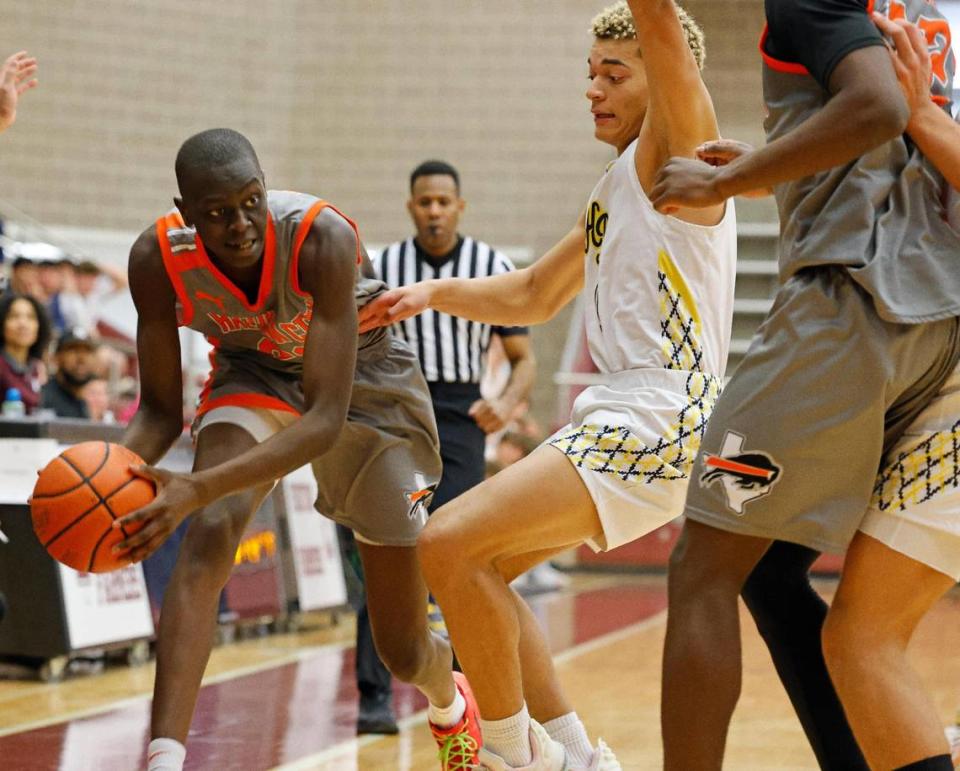 Haltom forward Kuol Atak (22) tries to get the ball out of a tight spot in the fourth period of a UIL Conference 6A Division 1 boys bi-district basketball playoff game at Lewisville High School in Lewisville, Texas, Tuesday, Feb. 20, 2024.