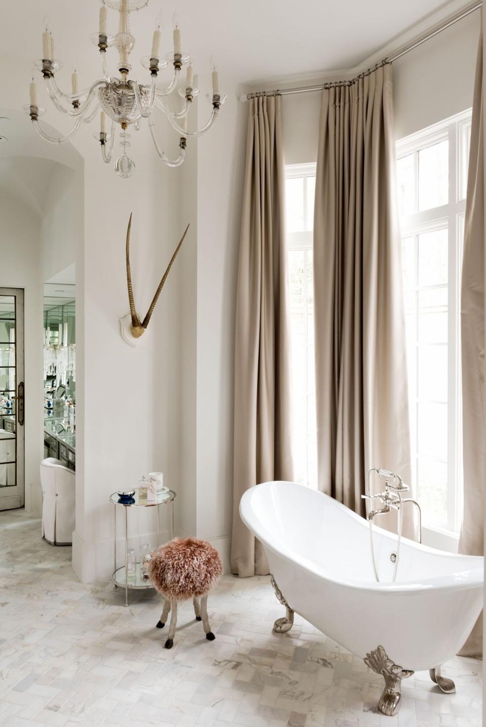 Soaking Tub in Front of Floor-to-Ceiling Windows with Draperies