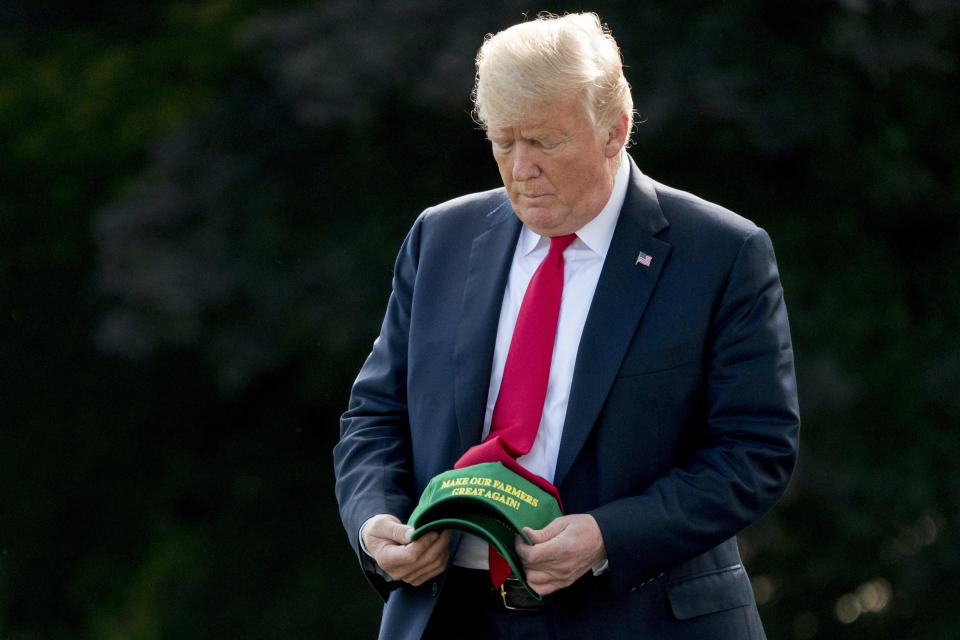 President Donald Trump hold hats that read "Make Our Farmers Great Again!" as he walks across the South Lawn before boarding Marine One at the White House in Washington, Thursday, Aug. 30, 2018. (Photo: AP/Andrew Harnik)