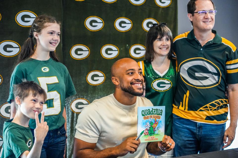 Green Bay Packers running back AJ Dillon poses for a photo with fans at a launch event for his new children's book, "Quadzilla Finds His Footing," Tuesday at the Johnsonville Tailgate Village outside Lambeau Field.