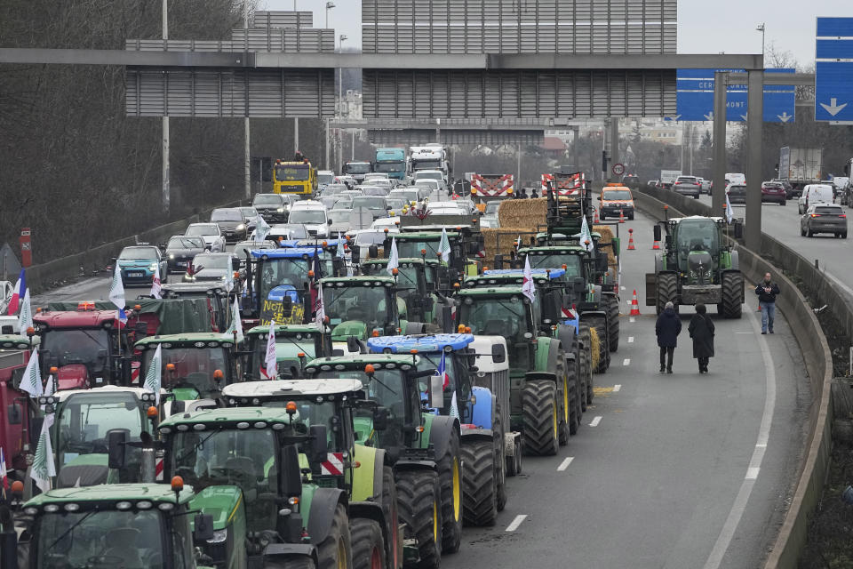 Tractors line up on a blocked highway, Thursday, Feb.1, 2024 in Argenteuil, north of Paris. France's two major farmers unions announced Thursday their decision to suspend protests and lift road blockades across the country, in a dramatic development shortly after the French prime minister unveiled a new set of measures they see as "tangible progress." Farmers have been protesting for days across the country to denounce low wages, heavy regulation and unfair competition from abroad. (AP Photo/Michel Euler)