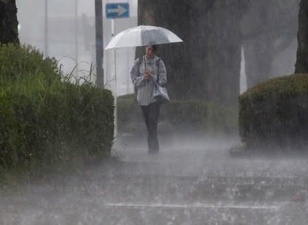 A pedestrian walks through heavy rain in Kirishima, Kagoshima Prefecture, southwestern Japan