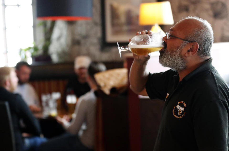 A man enjoys his first beer on the premises, at the Chandos Arms in London, Saturday, July 4, 2020. England is embarking on perhaps its biggest lockdown easing yet as pubs and restaurants have the right to reopen for the first time in more than three months. In addition to the reopening of much of the hospitality sector, couples can tie the knot once again, while many of those who have had enough of their lockdown hair can finally get a trim. (AP Photo/Frank Augstein)