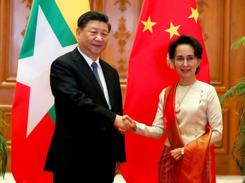 FILE PHOTO: Myanmar State Counselor Aung San Suu Kyi shakes hands with Chinese President Xi Jinping at the Presidential Palace in Naypyitaw