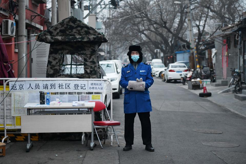 A security guard wears a facemask to protect against the COVID-19 coronavirus as he stands guard at a checkpoint at the entrance to an alley in Beijing on February 20, 2020. (Greg Baker/AFP via Getty Images)