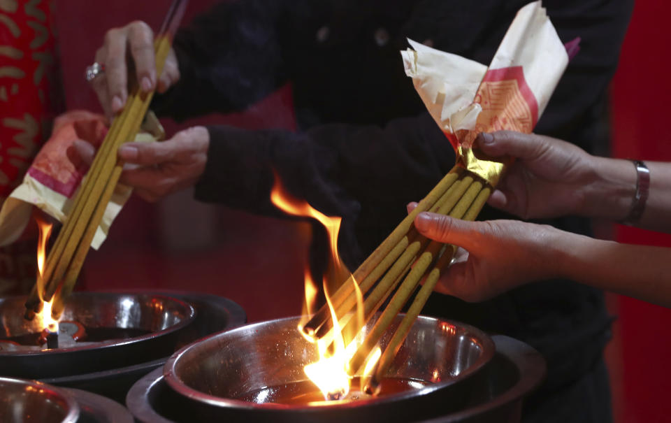 Ethnic Chinese worshippers light joss sticks during the Lunar New Year celebrations at a temple in the China Town area of Jakarta, Indonesia, Friday, Feb. 12, 2021. (AP Photo/Tatan Syuflana)