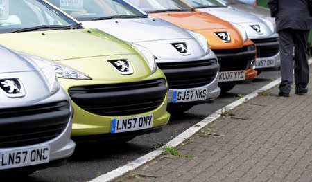 FILE PHOTO: Man passing cars on a showroom forecourt in west London