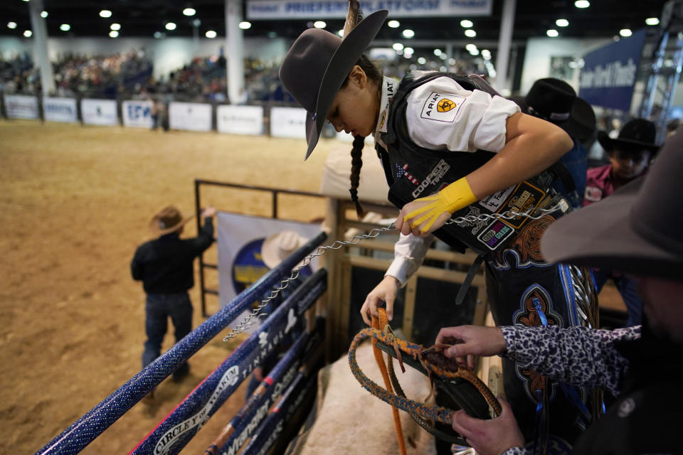 Najiah Knight prepares to ride a bull during the Junior World Finals rodeo, Thursday, Dec. 7, 2023, in Las Vegas. Najiah, a high school junior from small-town Oregon, is on a yearslong quest to become the first woman to compete at the top level of the Professional Bull Riders tour. (AP Photo/John Locher)