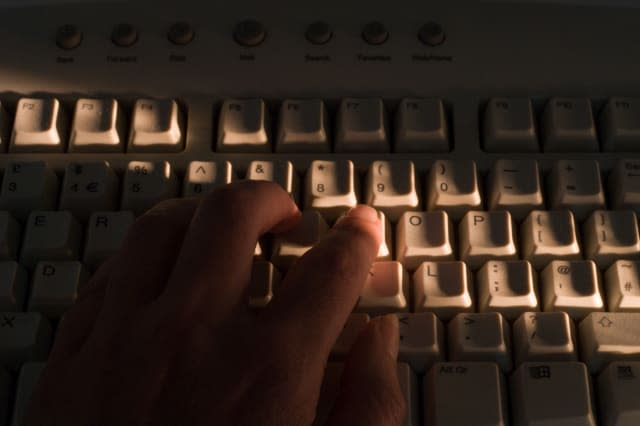 A42KRR Hand on computer keyboard, identity fraud concept. Image shot 2007. Exact date unknown.