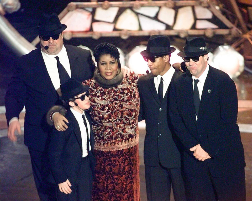 Aretha Franklin poses with the Blues Brothers (John Goodman, J. Evan Bonifant, Joe Morton, and Dan Aykroyd) at the 40th Grammy Awards in 1998.