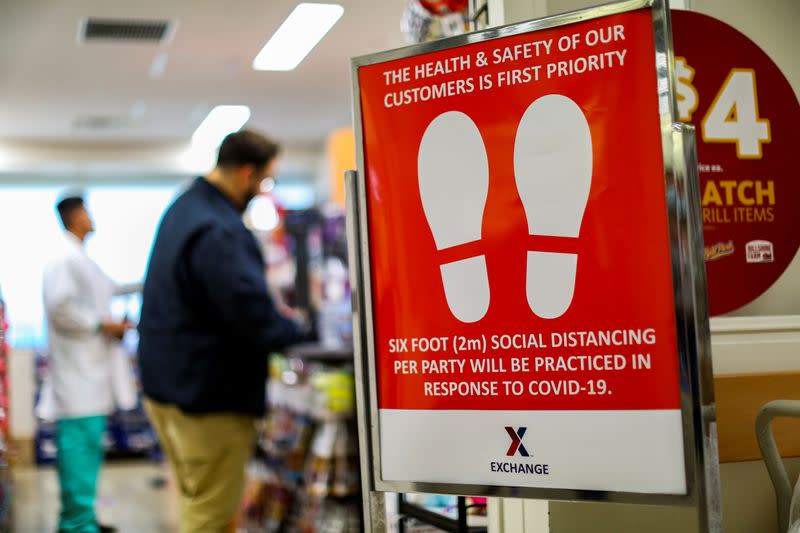 A cautionary sign is placed outside of U.S. Naval Hospital Okinawa exchange reminding personnel to practice social distancing