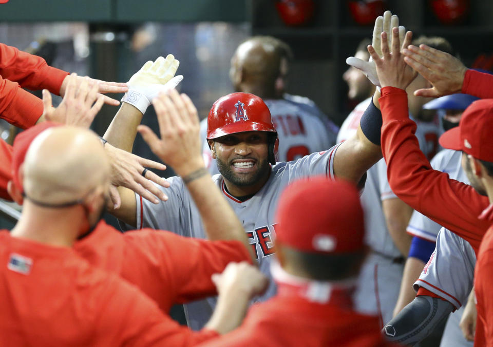 FILE - Los Angeles Angels first baseman Albert Pujols (5) is greeted in the dugout after a solo home run against the Texas Rangers in the third inning during a baseball game in Arlington, Texas, in this Monday, April 26, 2021, file photo. Pujols has been designated for assignment by the Los Angeles Angels, abruptly ending the 41-year-old superstar slugger's decade with his second major league team. The Angels announced the move Thursday, May 6, 2021, a day after Pujols wasn't in their lineup for their fourth consecutive loss. (AP Photo/Richard W. Rodriguez, File)