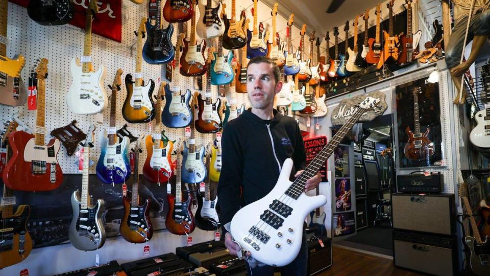 Joseph Daoust, general manager and son of the founders, shows a bass to a customer at Lightning Joe’s Guitar Heaven in Arroyo Grande. It began 40 years ago at the Nipomo Swapmeet and grew to a thriving guitar shop that fills a former bank location.