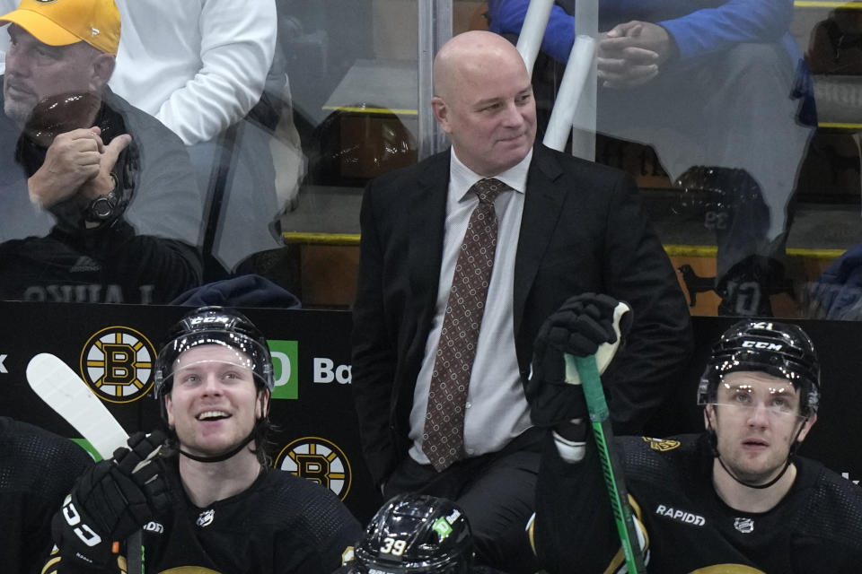 Boston Bruins head coach Jim Montgomery, center, watches from behind the bench as his team leads the Colorado Avalanche during the third period of an NHL hockey game, Thursday, Jan. 18, 2024, in Boston. (AP Photo/Steven Senne)