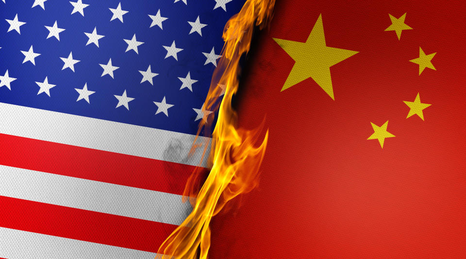 Burning American and Chinese flags are paired together. Realistic 3D lighting and high quality texture effect with copy space for your messages.