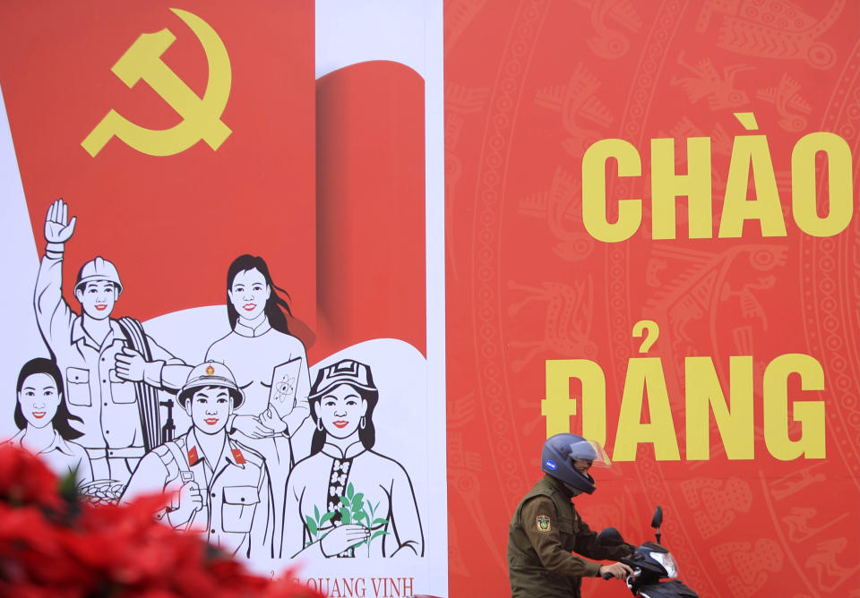 A man rides motorcycle past a poster promoting the Communist Party Congress in Hanoi, Vietnam, Saturday, Jan. 23, 2021. Almost 1,600 leading members of Vietnam's Communist Party on Tuesday, Jan. 26, 2021 begin a meeting to set policy for the next five years and select the group's senior members to steer the nation. (AP Photo/Hau Dinh)