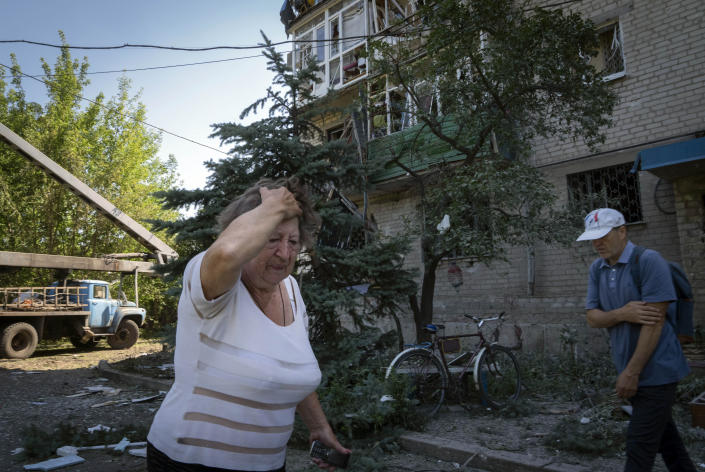 FILE - A woman reacts after the Russian shelling in city center in Slovyansk, Donetsk region, Ukraine, Monday, June 27, 2022. (AP Photo/Efrem Lukatsky)