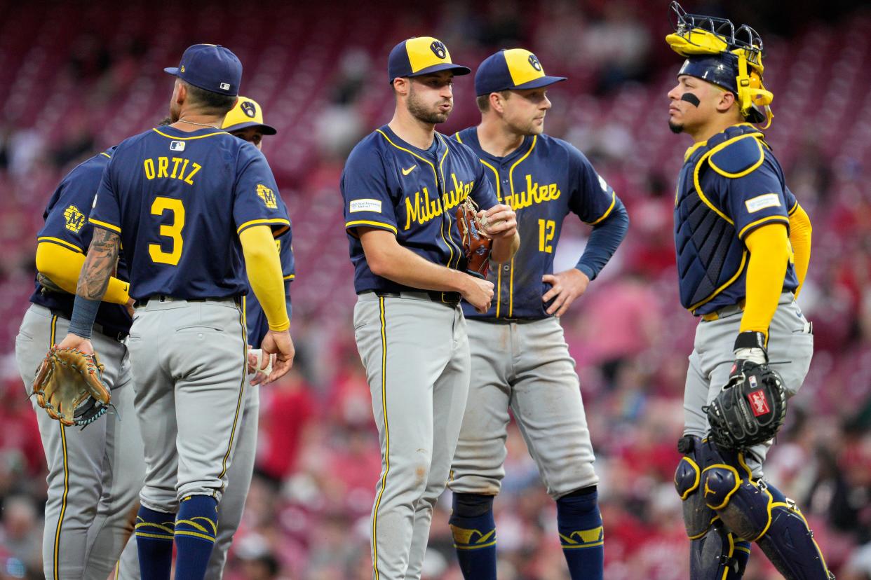 Brewers starter Aaron Ashby waits with teammates for a pitching change during the fourth inning Monday night at Great American Ball Park.