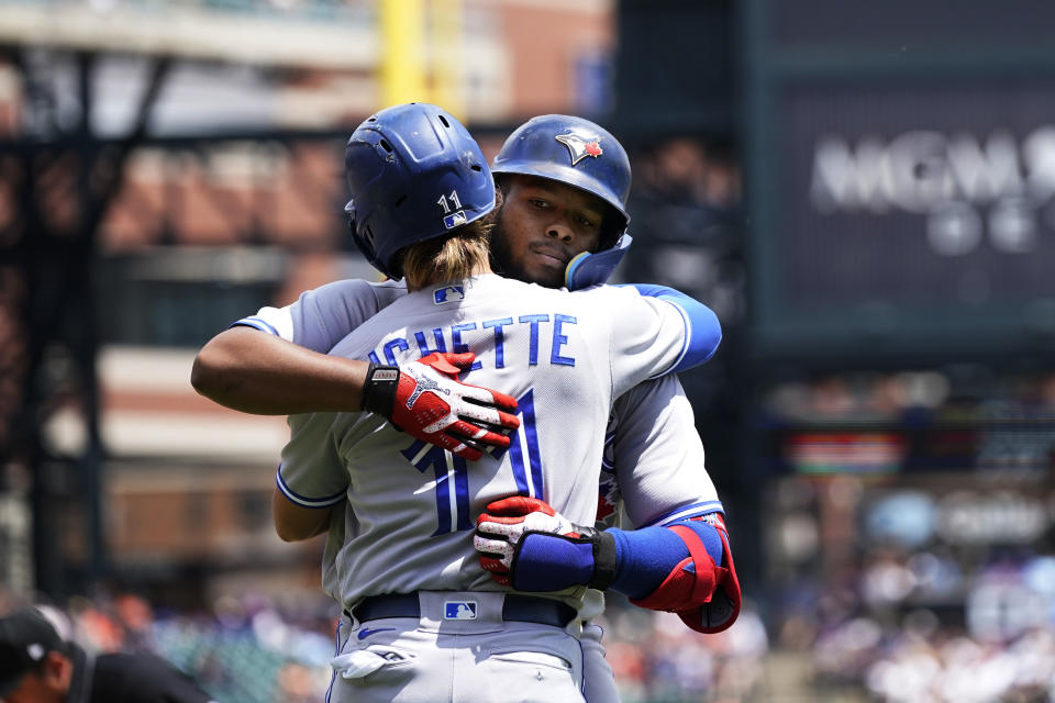 Toronto Blue Jays' Bo Bichette hugs Vladimir Guerrero Jr. after they both scored on Guerrero's two-run home run during the fourth inning of a baseball game against the Detroit Tigers, Sunday, June 12, 2022, in Detroit. (AP Photo/Carlos Osorio)