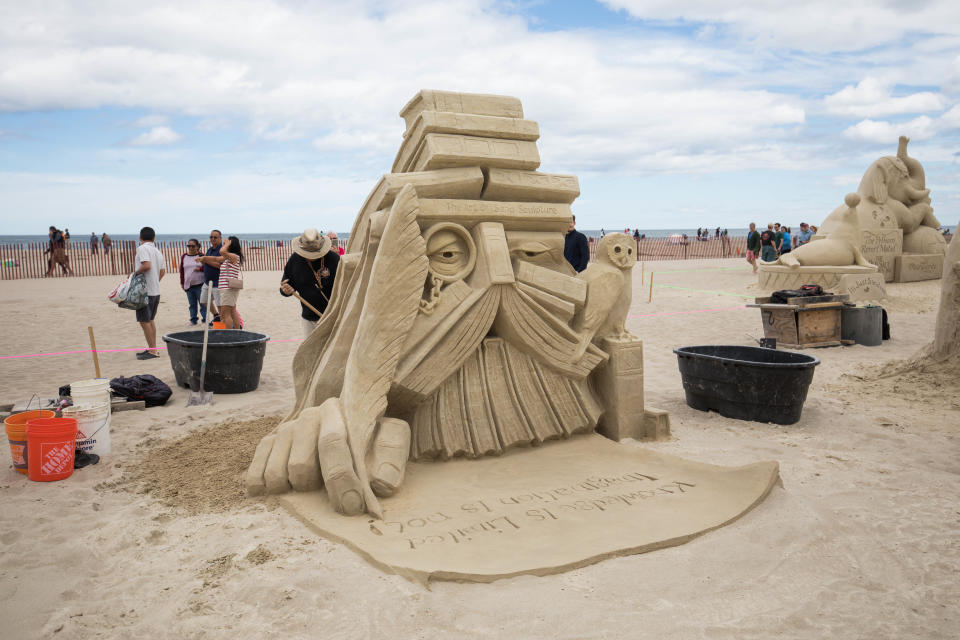 John Gowdy, of Italy and New Jersey, with "Knowledge is Limited.  Imagination Encircles the World," during the 2022 Hampton Beach Master Sand Sculpting Classic Saturday, June 18.