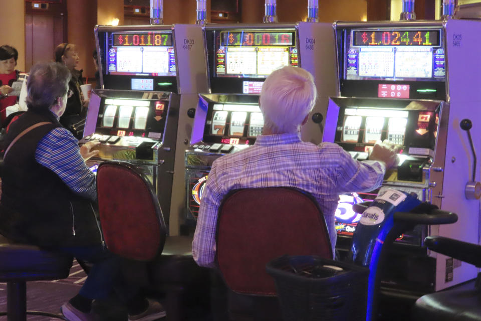 Gamblers play slot machines at Harrah's casino in Atlantic City, N.J. on Sept. 29, 2023. On Nov. 14, 2023 New Jersey gambling regulators released details of forfeitures they ordered totaling over $77,000 from five casinos and a racetrack that were found to have allowed underage or otherwise prohibited gamblers to make bets. (AP Photo/Wayne Parry)